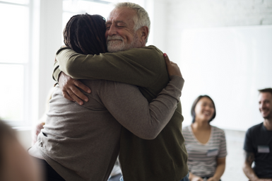 A man hugging a woman during a support group meeting