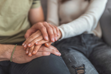 a close up of two people holding hands