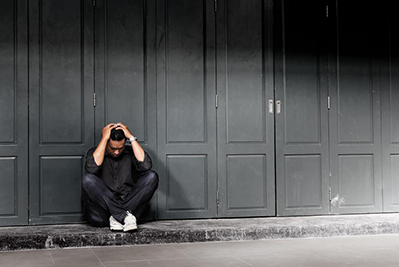 man sits with his head in his hands