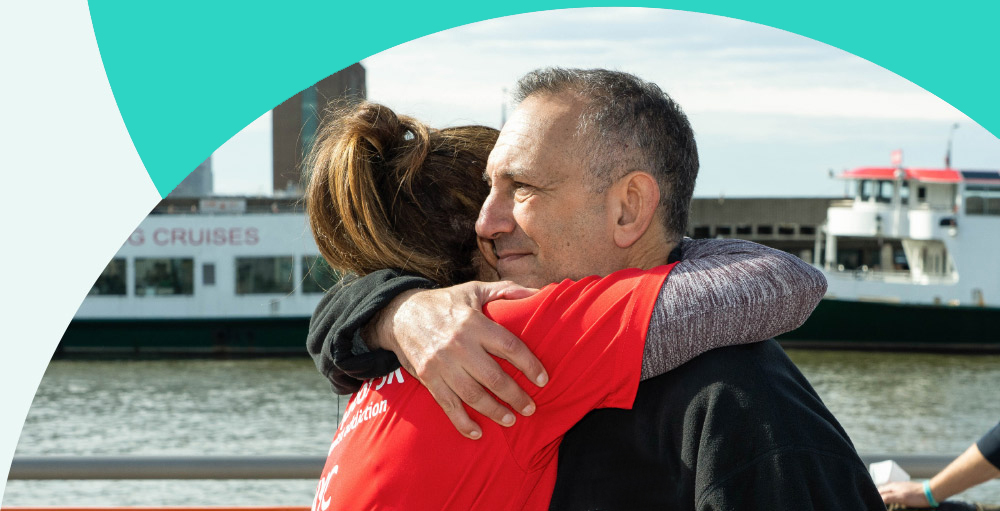 Gary Mendell hugging a volunteer