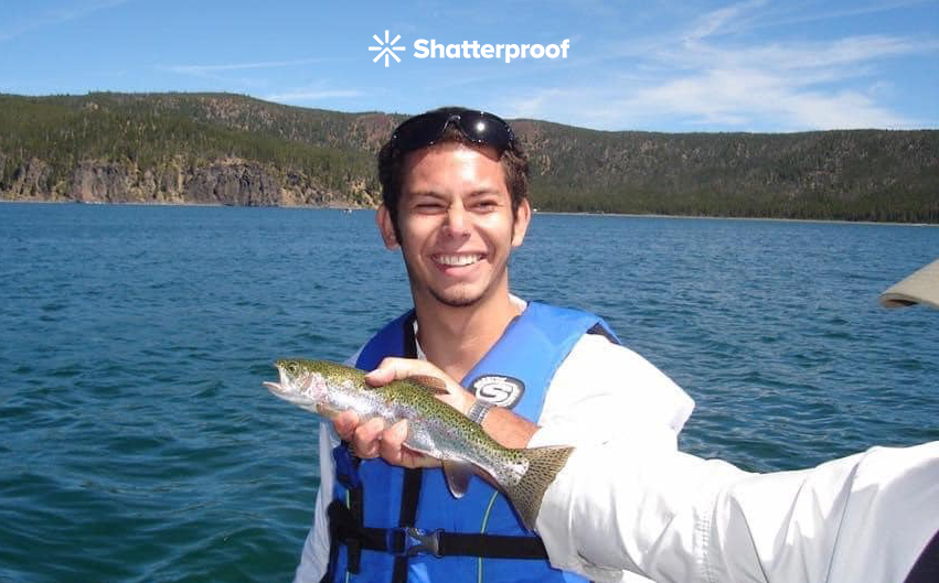 Brain standing in front of a lake and smiling 