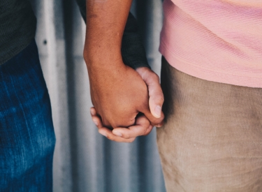 A close-up on two people holding hands
