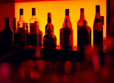 A stocked bar lit in orange and red