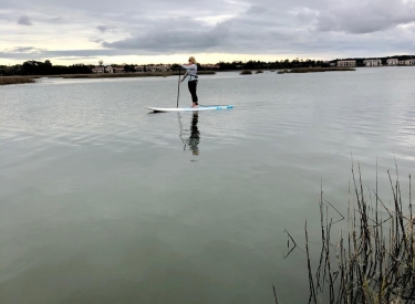The author on her stand-up paddle board on a cloudy day