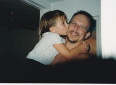 A childhood photo of the author and her dad hugging