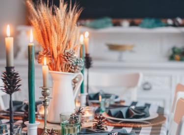 A table set for a holiday celebration, with lit candles and cloth napkins