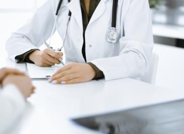 Doctor sitting at a table and talking to a patient