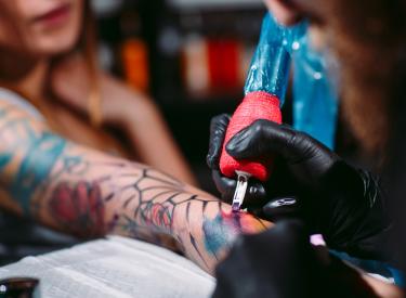 Woman getting tattooed