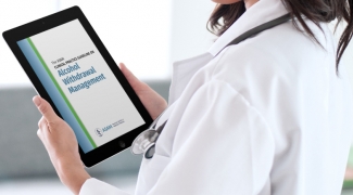 A doctor in a white coat holds an iPad which reads "ASAM Alcohol Withdrawal Management"