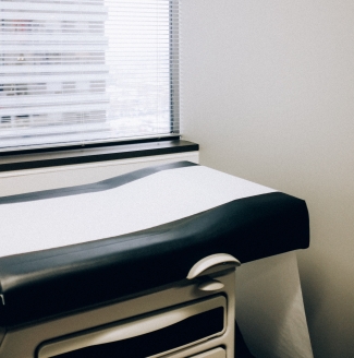 A table in a doctors office lined with paper. Photo by Charles Deluvio on Unsplash