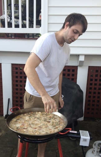The author's son, in a white t-shirt, cooking in a large pot